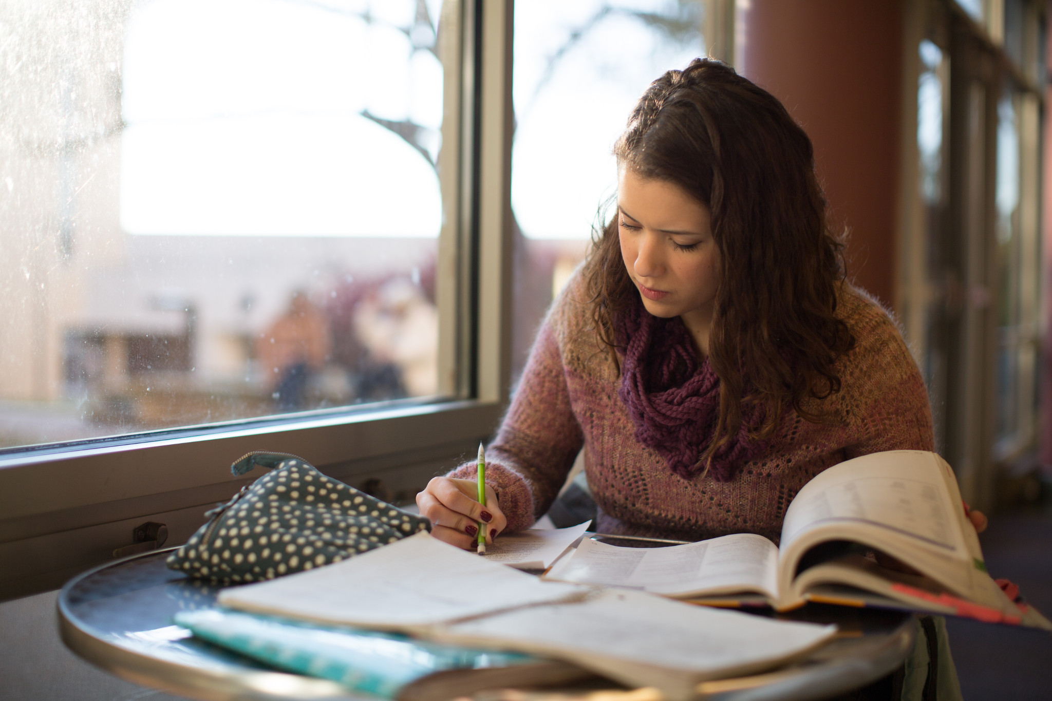 student sits at table studying