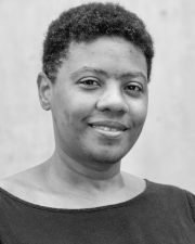 A young woman smiling in a black sweater.